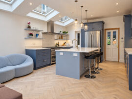 Open-plan kitchen extension in Teddington with grey kitchen island, rooflights and herringbone wood flooring